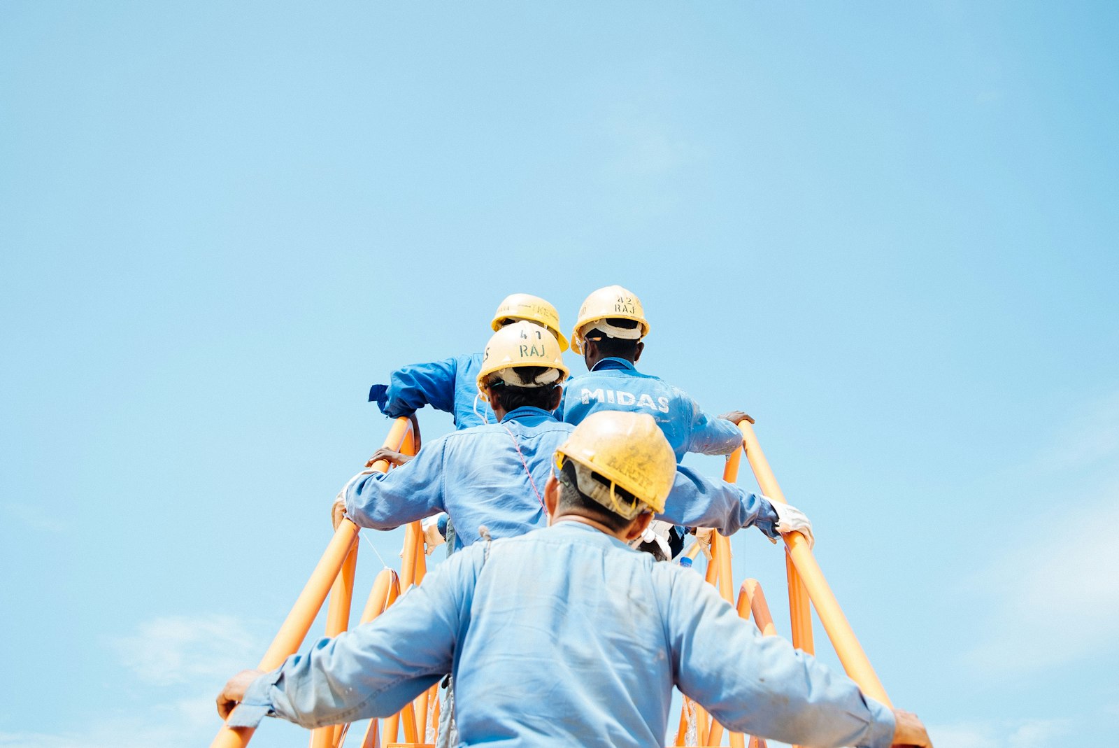 Équipe de chantier casquée observant un ouvrage en construction